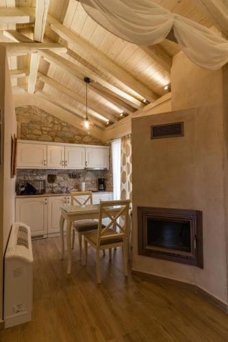 a kitchen with a table and a fireplace at Olea in Pirgos Dhirou