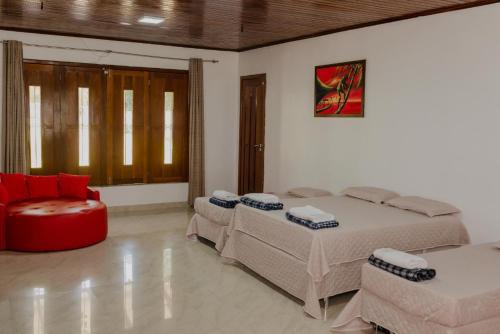 a bedroom with two beds and a couch and a chair at CASA NA PRAIA - 5 QUARTOS - PISCINA - CHURASQUEIRA e VISTA EXTRAORDINARIA - 20 PESSOAS in Santarém