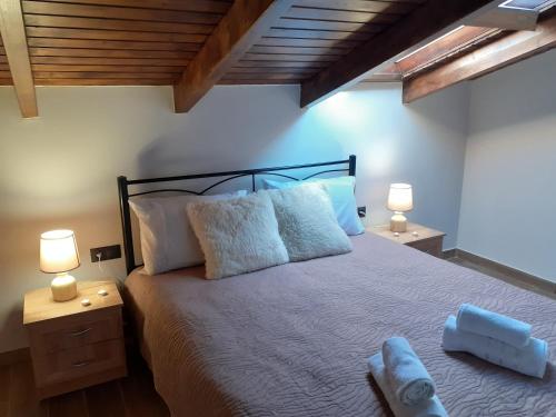 a bedroom with a large bed with two lamps at The view attic in Ioannina