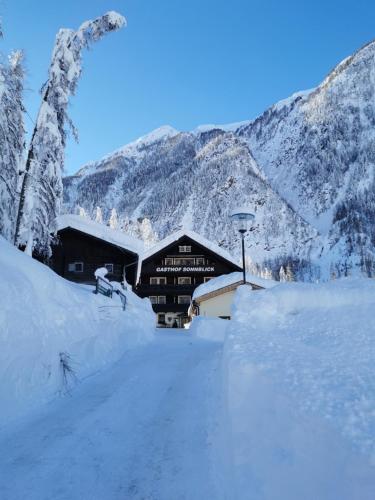a building covered in snow in front of a mountain at Hotel - Restaurant - Sonnblick in Heiligenblut