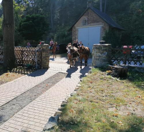 a group of people riding horses in front of a garage at Pension Goldbachmühle in Blankenburg