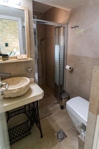 a bathroom with a sink and a shower and a toilet at Olea in Pirgos Dhirou