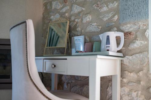 a white desk with a mirror and a chair at Olea in Pirgos Dhirou