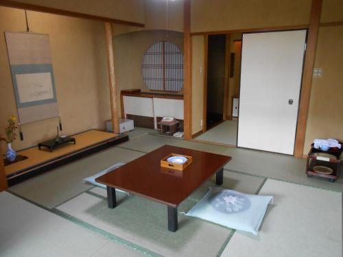 a living room with a table and a door at Shin Kadoya in Atami