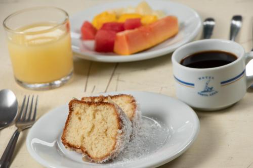 a piece of bread on a plate next to a cup of coffee at MOVA - Hotel Costa Azul in Ubatuba