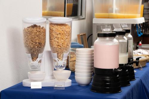 a table topped with two tall containers of food and bowls at MOVA - Hotel Costa Azul in Ubatuba