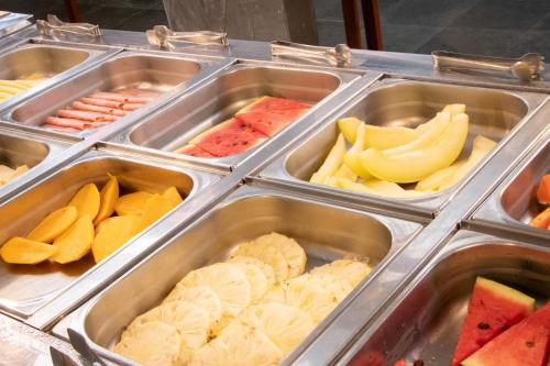 a buffet filled with trays of different types of food at MOVA - Hotel Costa Azul in Ubatuba