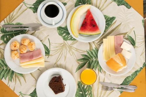 a table with plates of food and a cup of coffee at MOVA - Hotel Costa Azul in Ubatuba