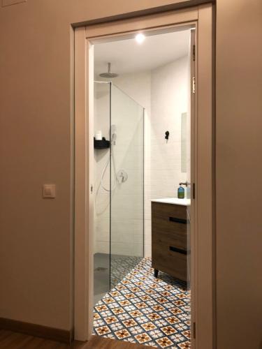 a bathroom with a glass shower and a sink at Mirador de San Juan in Toledo