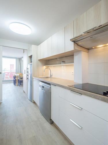 une grande cuisine avec des placards blancs et un évier dans l'établissement Les jardins de la Côte d'azur, à Saint-Mandrier-sur-Mer