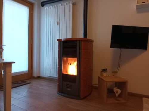 a fireplace in a living room with a fire in it at Ampio e grazioso trilocale con vista panoramica in Chiesa in Valmalenco