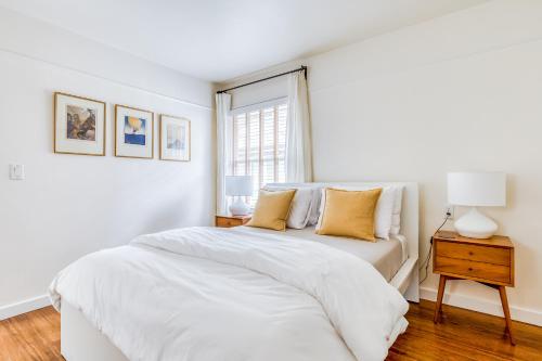 a white bedroom with a bed and a window at Lake Oswego Mid-Century in Lake Oswego