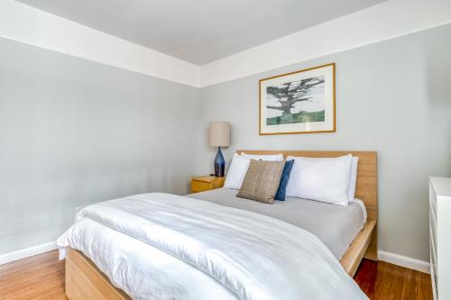 a white bedroom with a bed with white sheets at Lake Oswego Mid-Century in Lake Oswego