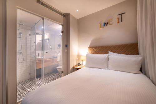 a bedroom with a large bed and a shower at Jacob Shenkin Hotel in Tel Aviv
