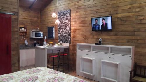 eine Küche mit einer Theke und einer Bar in einem Zimmer in der Unterkunft Pousada Sitio Bella Vista in Urupema