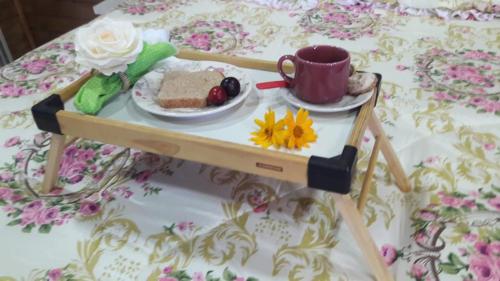 un vassoio con un piatto di cibo e una tazza su un tavolo di Pousada Sitio Bella Vista a Urupema