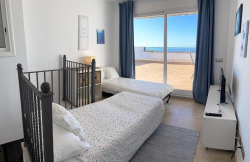 ein Wohnzimmer mit einem Sofa, einem Bett und einem Fenster in der Unterkunft Amazing duplex with large terrace and sea views in Puerto de Santiago