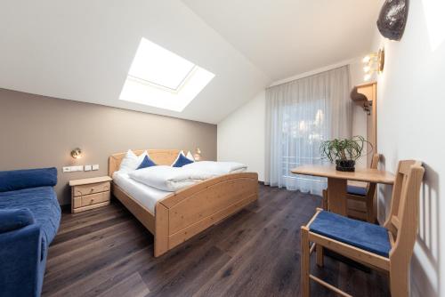 a bedroom with a bed and a couch at Hotel Berghang in Collepietra