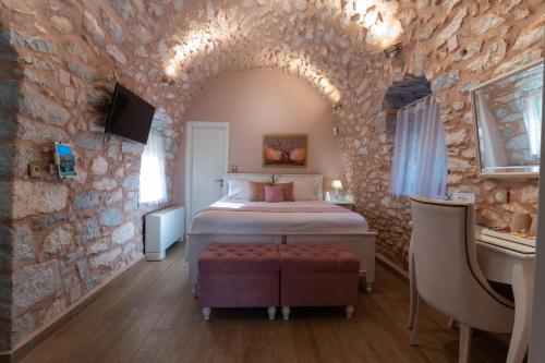 a bedroom with a bed in a stone wall at Olea in Pirgos Dhirou