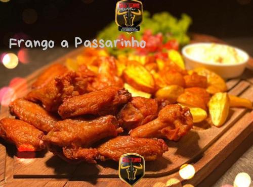 a plate of food with chicken and potatoes on a table at Herval Park Hotel in Ponta Porã