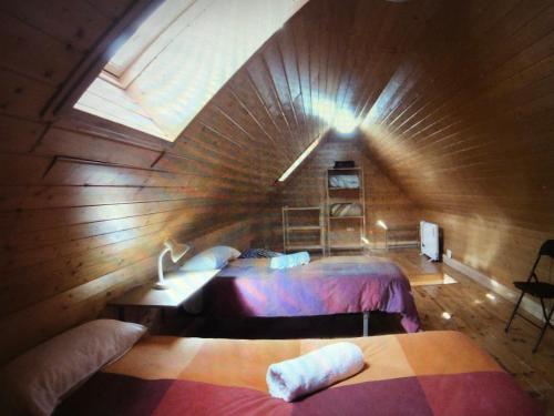 シエラネバダにあるCasita de madera Alpes 6の木造キャビン内のベッド2台が備わる広い客室です。