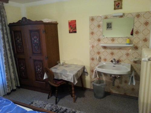 een kleine badkamer met een wastafel en een tafel bij St. Christoph in Gerlos