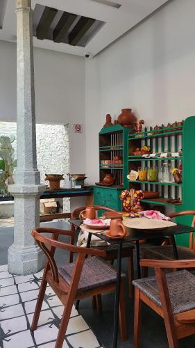 uma mesa e cadeiras numa cozinha com prateleiras verdes em Casa Naila Hotel Boutique em Oaxaca City