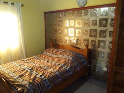 1 dormitorio con 1 cama y una pared de cuadros en Résidence Cristal Logpom, en Douala
