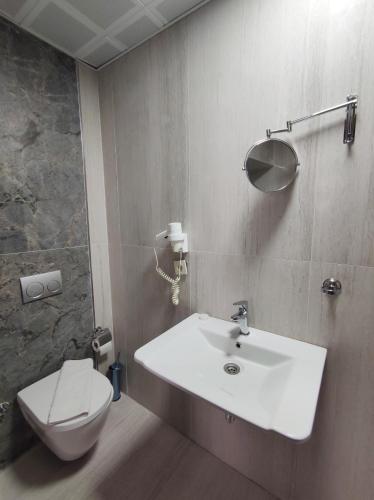 a bathroom with a white sink and a toilet at The Golden Pera's Hotel & Spa in Istanbul