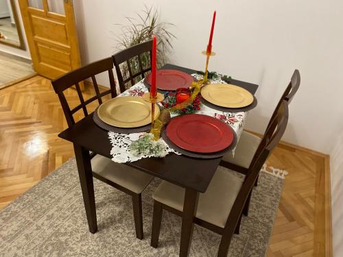 a dining room table with plates and candles on it at Home away - Chic and Cozy Apartment in Constanţa