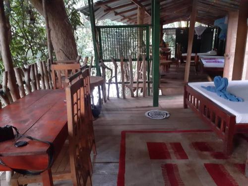 a room with a table, chairs, and a pool at River Side Cabana in Tissamaharama