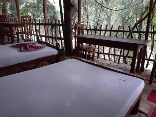 a bed room with two beds and a window at River Side Cabana in Tissamaharama