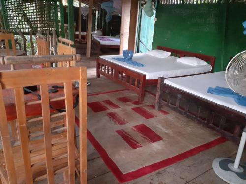 a room with two beds and a table and chairs at River Side Cabana in Tissamaharama