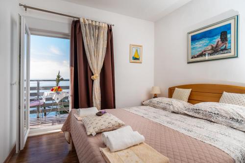 sypialnia z dużym łóżkiem i balkonem w obiekcie Apartments Tolic w Baskiej Vodzie