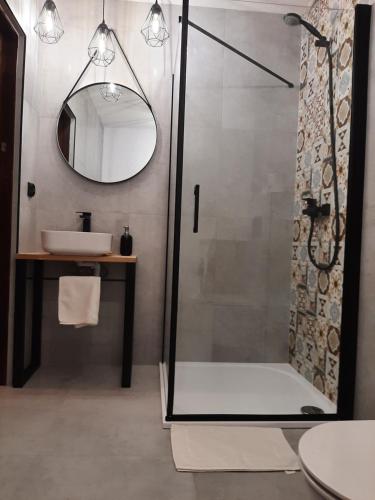 a bathroom with a shower and a sink and a mirror at Dwupiętrowy Apartament Grota 2 in Zakopane
