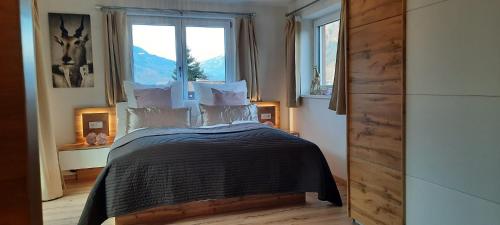 a bedroom with a bed in a room with windows at Haus Schober in Bad Hofgastein