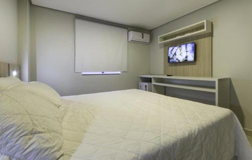 a bedroom with a bed and a flat screen tv at WR Confort Hotel Campo Grande in Campo Grande