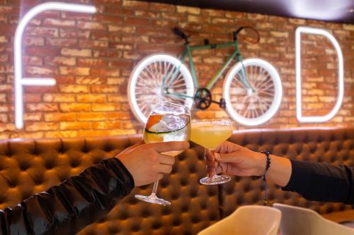 two people holding drinks in their hands in front of a bike at Novotel Mexico City Toreo in Mexico City