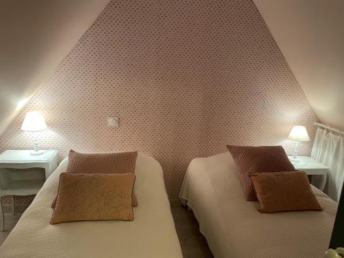 a bedroom with two beds and two tables and two lamps at les gites du grand saule in Tardinghen