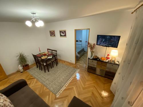 a living room with a table and a television at Home away - Chic and Cozy Apartment in Constanţa