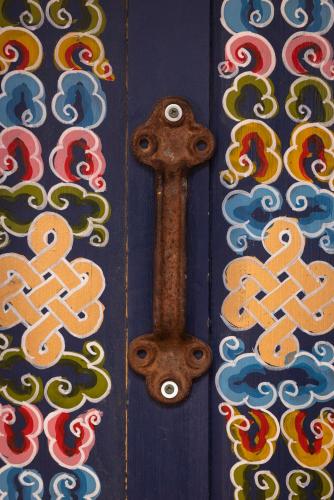 a wooden door with a handle and colorful designs on it at Family Style Star gazing Yurt in Twentynine Palms