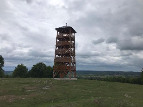 a clock tower on top of a grass field at Central Chalet in Vărşag