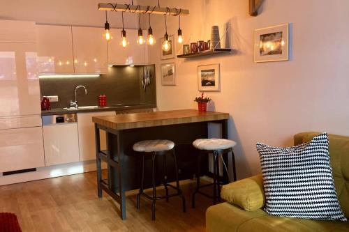 a kitchen with a bar with stools and a couch at Apartment Hucklehaus in Aich