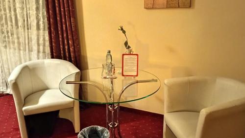 a glass table with two chairs and a sign on it at Centrum Konferencyjne Sułtan in Marki