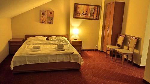 a bedroom with a bed and a table and chairs at Centrum Konferencyjne Sułtan in Marki
