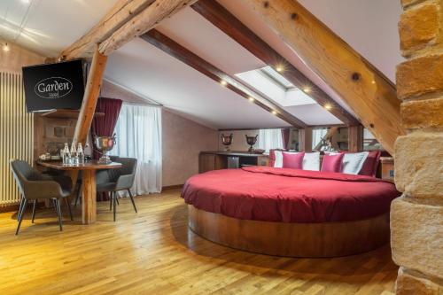 a bedroom with a red bed and a table and chairs at Garden Wellness Hotel S in Andalo
