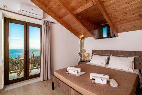 a bedroom with a bed with a view of the ocean at Villa Foteini in Skinária