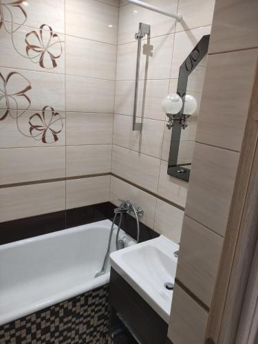 a bathroom with a bath tub and a sink at Тисовець квартира in Tysovets