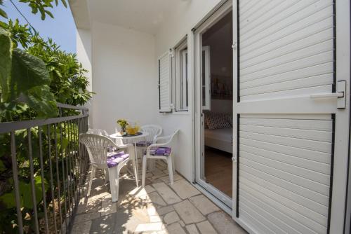 a patio with a table and chairs on a balcony at Apartment Zivkovic in Rogoznica