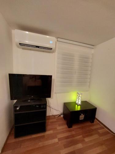 Una sala de estar con un televisor de pantalla plana y una mesa. en Borsko jezero, en Bor